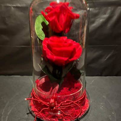 Urna con dos rosas preservadas.